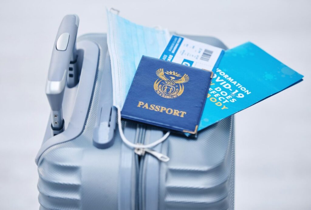 covid passport and suitcase for travel compliance policy and documents in global airport or visa