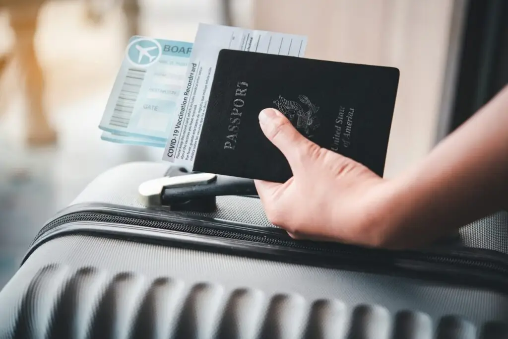 people holding passports and coronavirus vaccination record card
